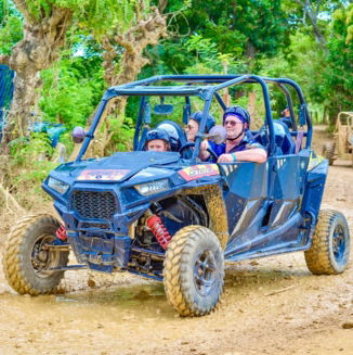 A group of people riding buggies down a dirt road during a Punta Cana Trip tour.