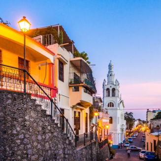 A horse drawn carriage in front of a stone building on Santo Domingo's Zona Colonial.